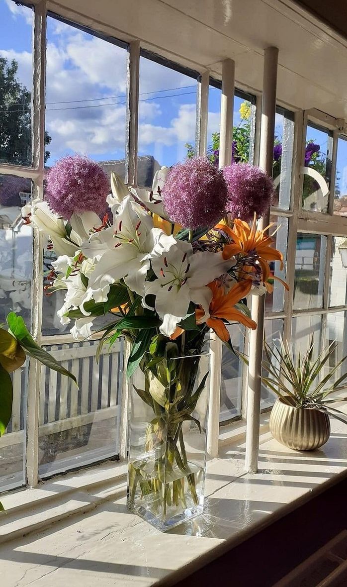 A collection of flowers on the windowsill of The Cricketer's Inn